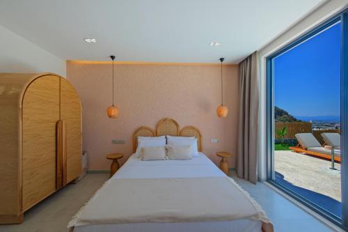 a bedroom with a bed and a large window at Casa Di Sabbia 1 in Fethiye