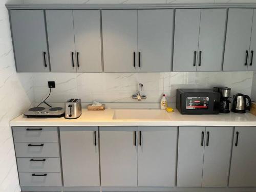 a kitchen with white cabinets and a sink and a microwave at Al Hada Hills Residential Unit in Al Hada