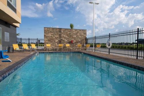 - une piscine avec des chaises et une clôture dans l'établissement Fairfield Inn & Suites by Marriott Houma Southeast, à Houma