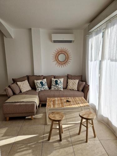 un salon avec un canapé et deux tables dans l'établissement Les flamants roses de la Capte T3, à Hyères