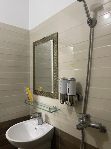 ein Bad mit einem Waschbecken und einem Spiegel in der Unterkunft HOTEL HOÀNG GIA in Lai Châu
