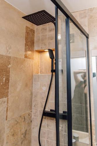 une douche avec pommeau de douche dans une salle de bain dans l'établissement Studio design rénové/ Berges du Rhone, à Lyon