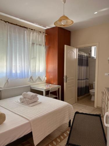 - une chambre avec un lit blanc et une salle de bains dans l'établissement Stergios_Apartments 01, à Kozani