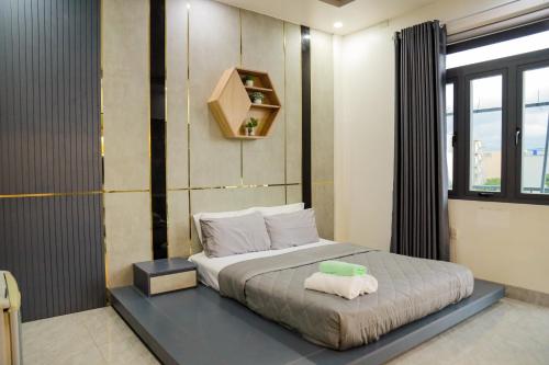 a bedroom with a bed with a green bowl on it at Cherry Hotel Bến Lức in Bến Lức