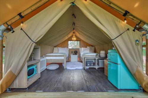a tent with a kitchen and a refrigerator in it at All That Glitters - Safari Tent - BeeWeaver Honey Farm in Navasota