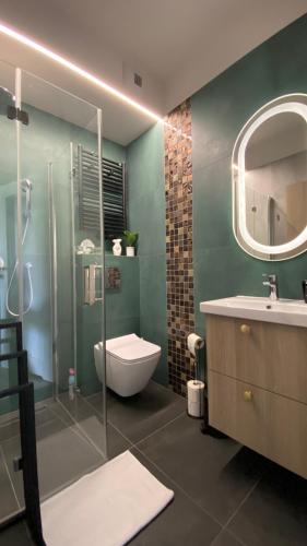 a bathroom with a toilet and a sink and a mirror at Apartament GJ PLAZA in Kielce