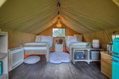 a room with two beds in a tent at All That Glitters - Safari Tent - BeeWeaver Honey Farm in Navasota