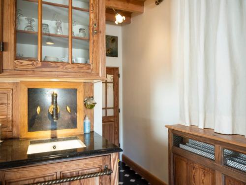 a kitchen with a sink and a wooden cabinet at De dag des Heeren in Merendree