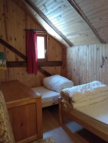 Zimmer mit 2 Betten in einer Holzhütte in der Unterkunft Chalet les Chardons in Celliers