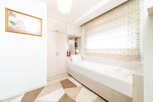 een witte badkamer met een raam en een witte bank bij Flat with Pool Balcony 7 min to Konyaalti Beach in Antalya