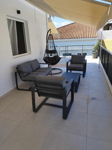 a patio with a couch and chairs and a swing at Petmeza Top Aigio City F in Aígio