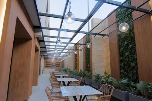 una fila di tavoli e sedie in un corridoio con piante di شقق عبية الفندقية a Riyad