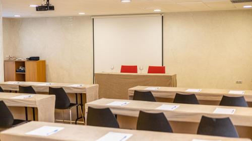 a classroom with tables and chairs and a screen at Seth Port Ciutadella in Ciutadella