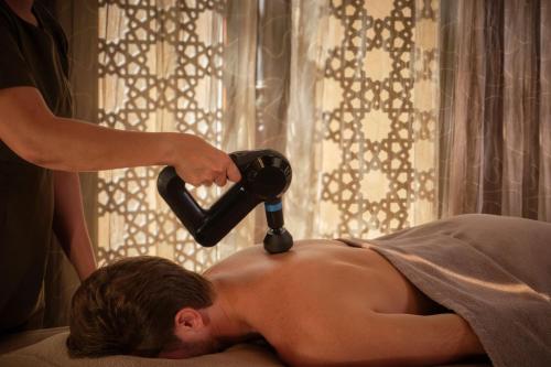 a man getting his hair cut with a hair dryer at The Ritz-Carlton Ras Al Khaimah, Al Wadi Desert in Ras al Khaimah