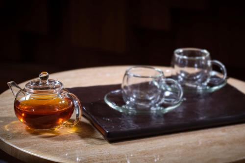 a table with two glasses and a jar of honey at The Ritz-Carlton Ras Al Khaimah, Al Wadi Desert in Ras al Khaimah