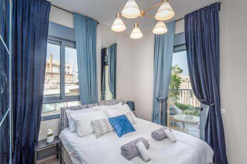 a bedroom with a large bed with blue curtains at Luxury 2BR with Nice View - Next King David Hotel in Jerusalem