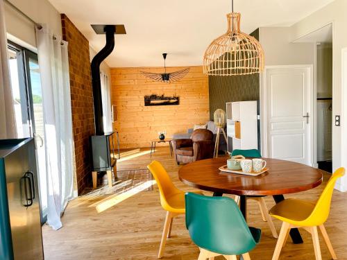 a living room with a wooden table and yellow chairs at Gites-domainedupin, cottage "Mosnes à Lisa" in Mosnes