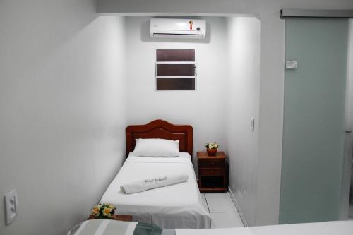 a small room with two beds and a window at Novo Hotel in Boa Vista