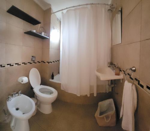 a bathroom with a white toilet and a sink at Terraza del Plaza in Rosario