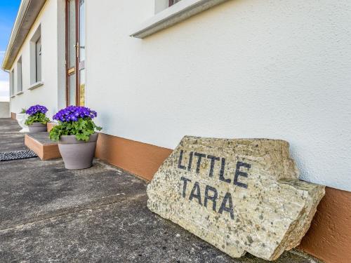 a rock sign sitting on the side of a building at Little Tara, Ballyconneely in Ballyconneely