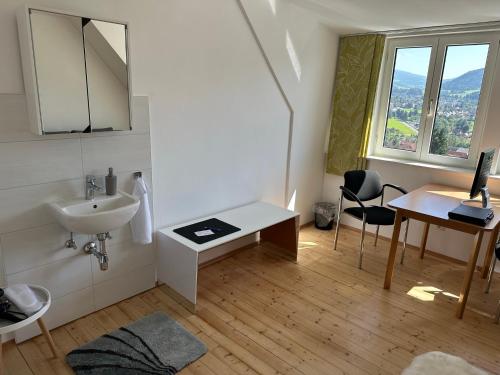 a bathroom with a sink and a desk with a computer at Panoramablick Scheifling in Lind bei Scheifling