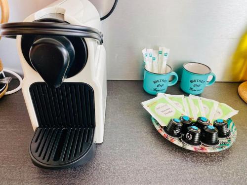 a coffee maker on a counter next to a plate with cups at ''Sienne'' Superbe T4 climatisé à 2 pas des Halles ! in Sète
