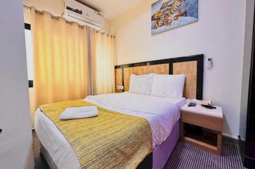 sypialnia z dużym łóżkiem i żółtym kocem w obiekcie Sharjah Plaza Hotel w Szardży