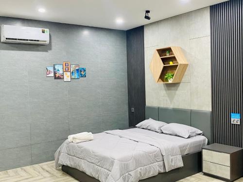 a bedroom with a bed and a tv on a wall at Cherry Hotel Bến Lức in Bến Lức