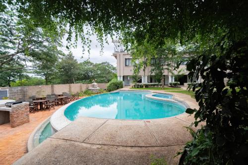 a swimming pool in front of a house at Pristine deluxe room with kitchen and pool - 2147 in Victoria Falls