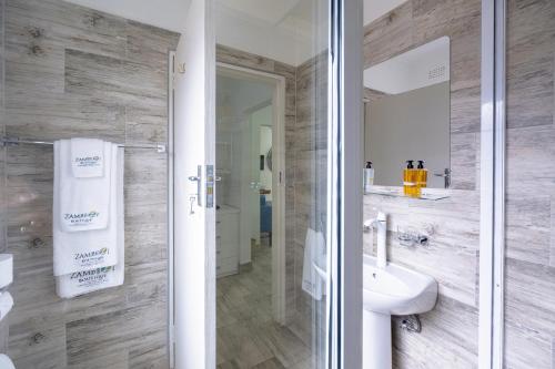 uma casa de banho com um lavatório e um espelho em Modern deluxe with kitchenette and pool - 2148 em Victoria Falls