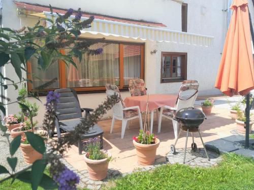 une terrasse avec une table, des chaises et un parasol dans l'établissement Ferienwohnungen Dürringer, à Owingen