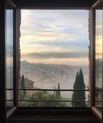 a window with a view of a foggy city at Antica Torre del Borgo in Certaldo