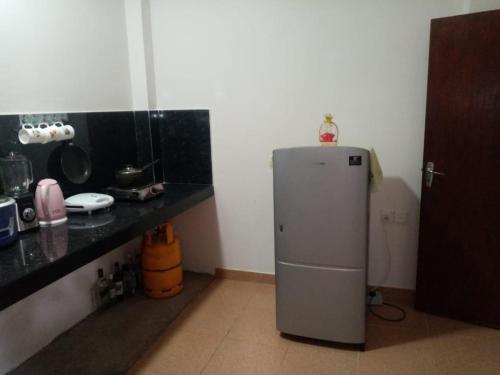 La cuisine est équipée d'un petit réfrigérateur et d'un comptoir. dans l'établissement House of Rose, à Dodanduwa