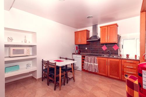 a kitchen with a table and a microwave at Casa Morgado by NaturAlegre in Alegrete