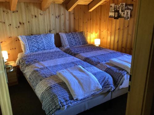 um quarto com 2 camas com edredões azuis em Dorril SUNNY & QUIET chalet 10 pers by Alpvision Résidences em Veysonnaz
