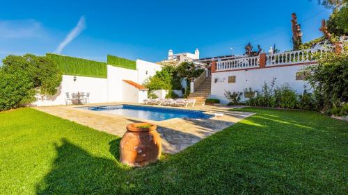 a yard with a large vase in front of a house at Villa Las Flores Frigiliana by Ruralidays in Frigiliana