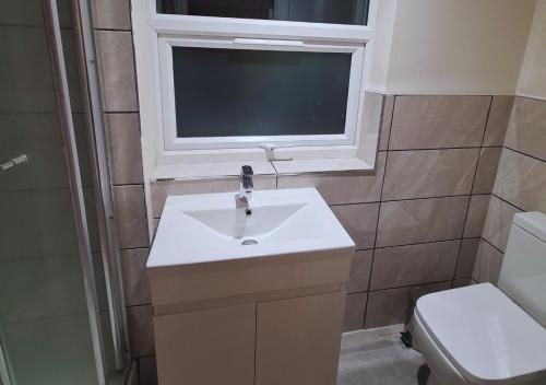 baño con lavabo, ventana y aseo en Modern 2 Bedroom Apartment in Peckham London, en Londres