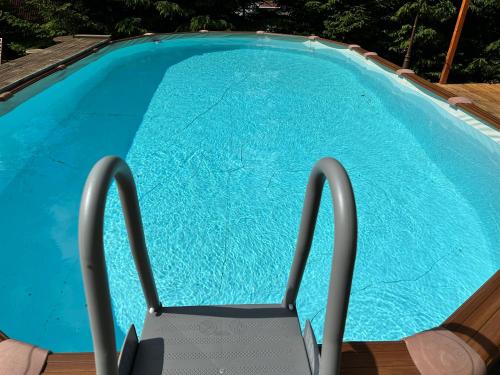 a swimming pool with a chair in front of it at Villa Adis with Hot Pool & Jacuzzi by BookVillaBG in Borovets