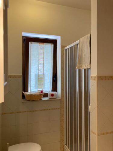 La salle de bains est pourvue de toilettes et d'une fenêtre. dans l'établissement Stanza Sole, à Ragalna