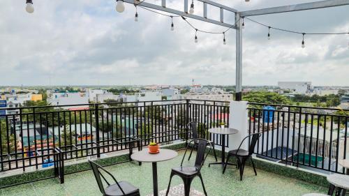 a balcony with tables and chairs and a view of a city at Cherry Hotel Bến Lức in Bến Lức