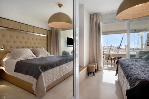 a bedroom with a large bed and a balcony at Puerto Marina exclusive apartment in Benalmádena