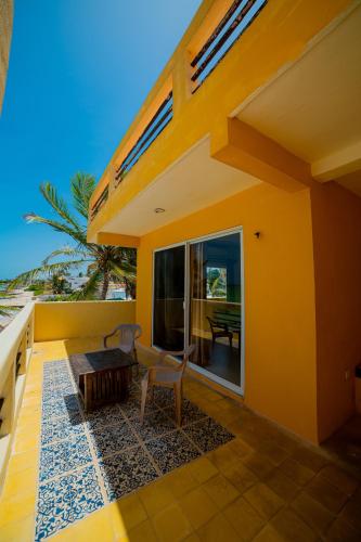 a balcony of a house with a table and chairs at Hotel Flamingos Inn in Chuburná