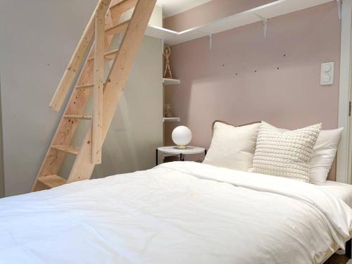 a bedroom with a white bed and a wooden ladder at Luxury apartement in Oslo in Oslo