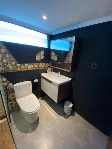 een badkamer met een wit toilet en een wastafel bij Modern LOFT studio apartment in Sanur