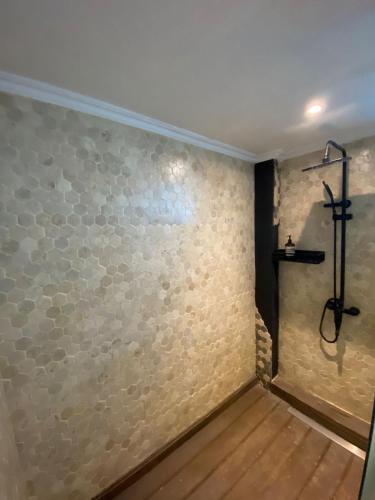een badkamer met een stenen muur en een douche bij Modern LOFT studio apartment in Sanur