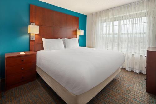 a bedroom with a large bed and a large window at Residence Inn Minneapolis Plymouth in Plymouth