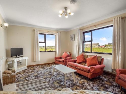 a living room with two couches and a tv at Little Tara, Ballyconneely in Ballyconneely