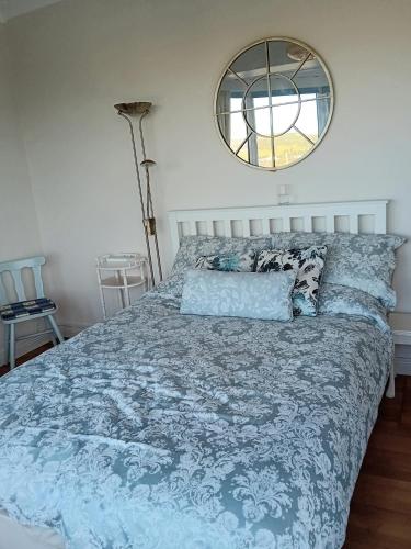 Schlafzimmer mit einem Bett mit blauer Decke und einem Spiegel in der Unterkunft ATLANTIC VIEW PORTNOO in Clogher