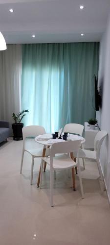a white table and chairs in a room at Crete Apart House - South in Ayía Marína