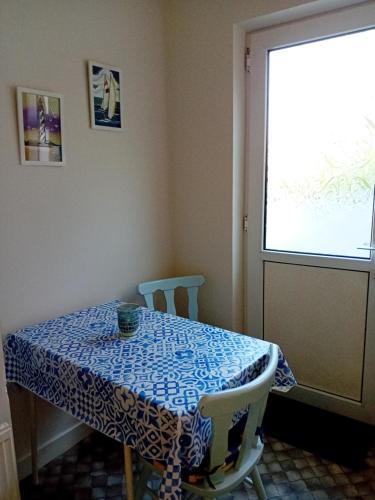uma mesa azul e branca com duas cadeiras e uma janela em ATLANTIC VIEW PORTNOO em Clogher
